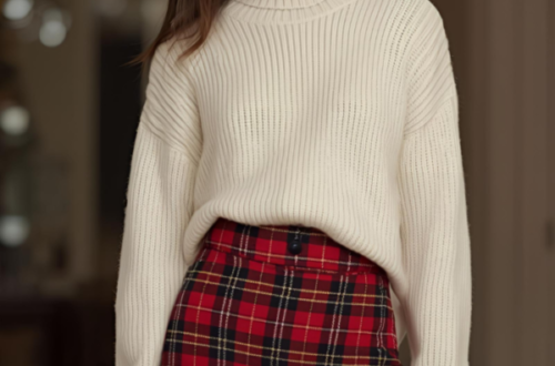 Woman wearing a beige sweater, red plaid skirt, and black knee-high boots for a cozy and stylish Christmas outfit.