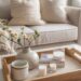 Coffee table styled for spring with fresh flowers, candle, and decorative tray, light-colored couch in the background